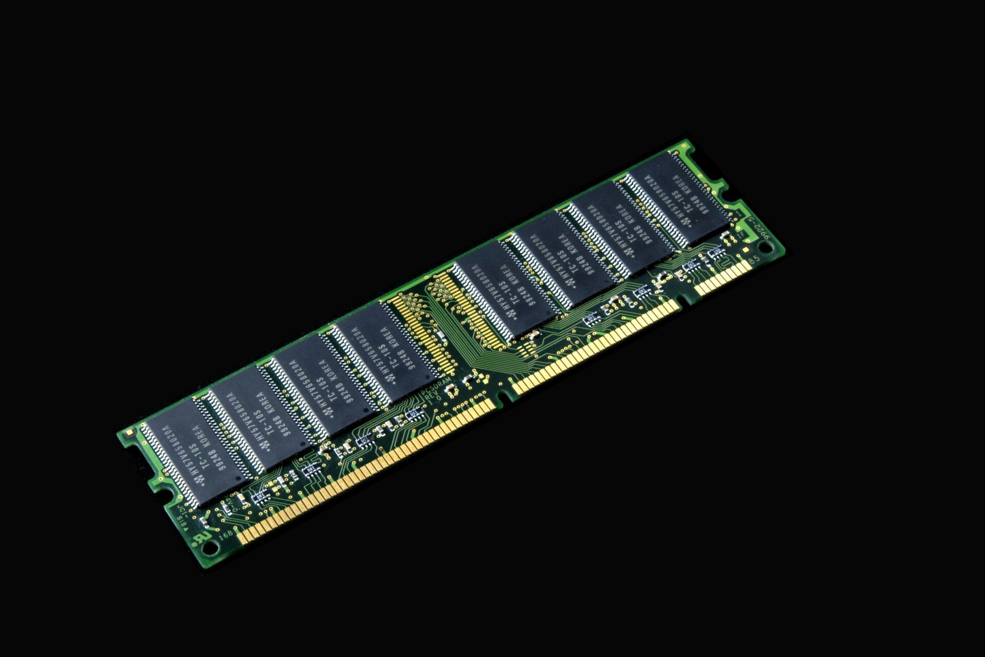 A secure computer RAM module with multiple black memory chips is mounted on a green circuit board, shown against a solid black background.